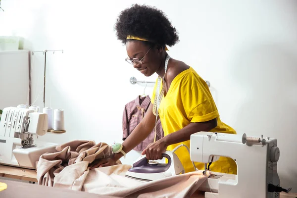 Mujer africana costurera planchado de tela — Foto de Stock