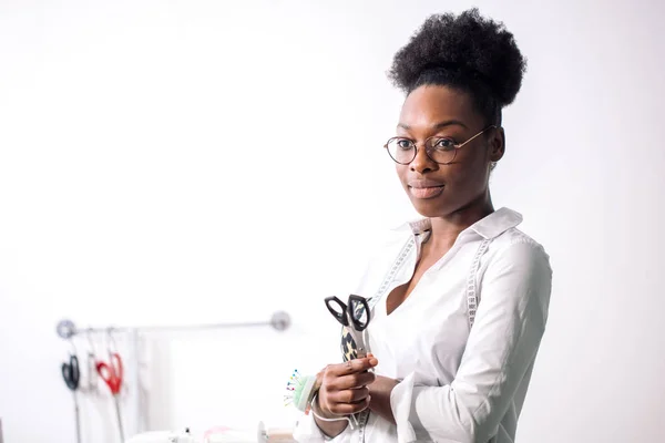 Lächelnde Näherin blickt mit Nähmaschine in die Kamera — Stockfoto