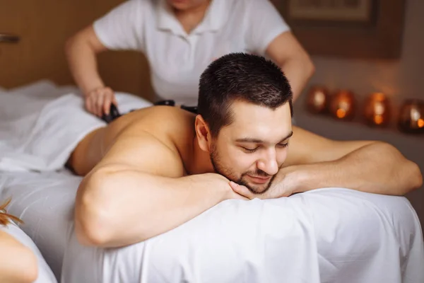 Man har sten massage i spasalong. Hälsosam livsstilskoncept — Stockfoto