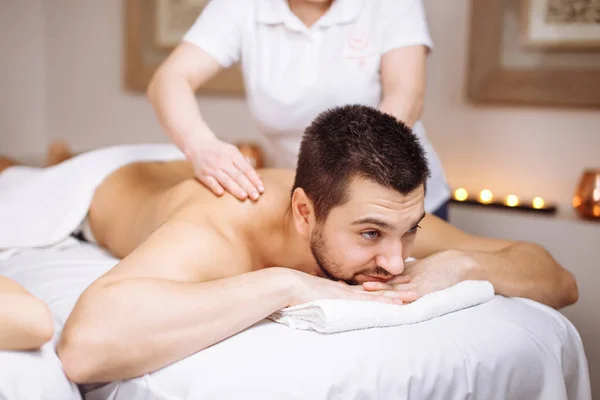 Hombre recibiendo masaje de espalda de masajista en spa —  Fotos de Stock