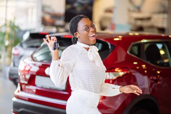 Mulher africana com seu novo carro mostrando chave — Fotografia de Stock