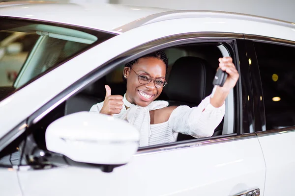 Donna africana con la sua nuova auto mostrando la chiave — Foto Stock