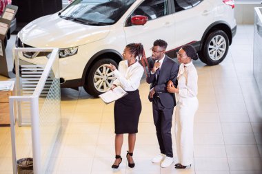 Araba özellikleri hakkında müşteriler için söylüyorum galerisinde duran araba satıcısı