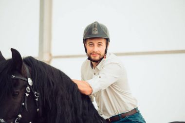üzerinde kahverengi bir binicilik tişörtlü adam