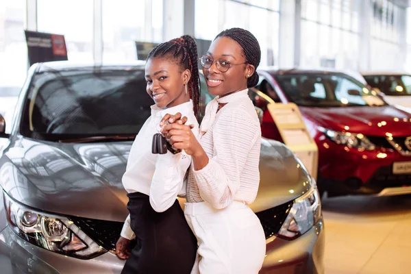 Zwei afrikanisch-amerikanische Frau in der Nähe von Auto mit Schlüssel in der Hand - Konzept des Autokaufs — Stockfoto