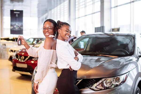 Duas afro-americanas perto de carro com chaves na mão conceito de compra de carro — Fotografia de Stock
