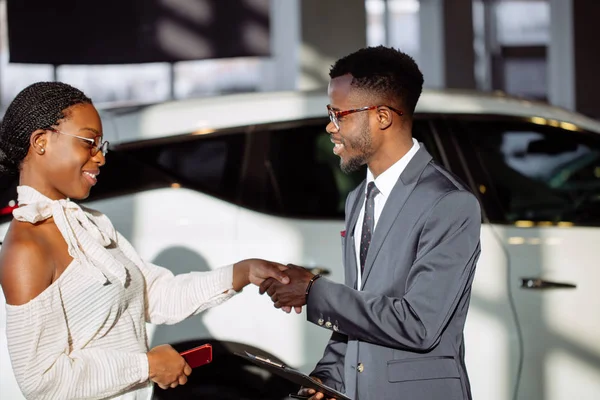 Customer buying a vehicle at car dealership. woman and man handshaking — Stock Photo, Image