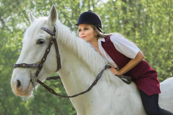 Morena mujer equitación oscuro caballo en verano verde bosque . —  Fotos de Stock