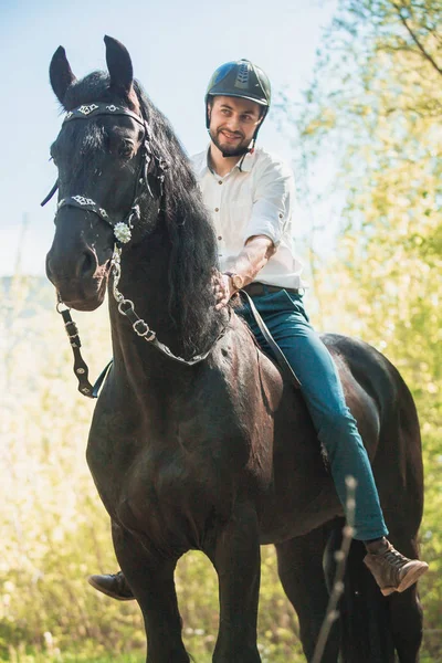 Человек в рубашке на коричневой лошади — стоковое фото