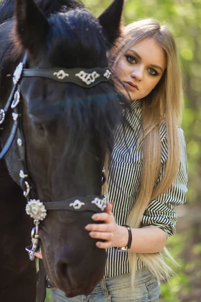Beautiful girl stroking horse outside — Stock Photo, Image