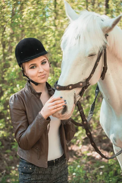 Schönes Mädchen streichelt Pferd draußen — Stockfoto