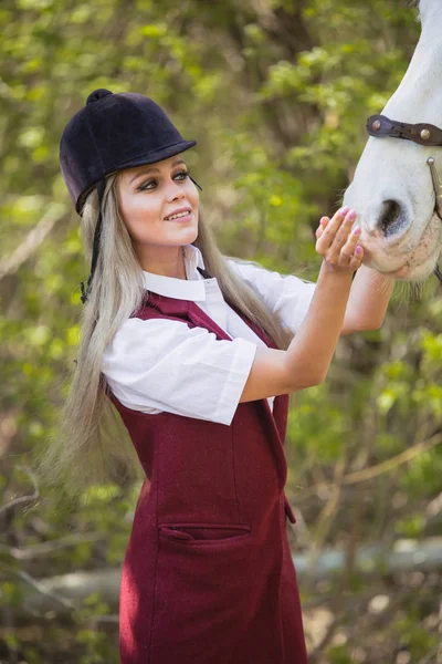 Schönes Mädchen streichelt Pferd draußen — Stockfoto