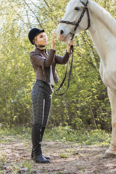 Beautiful girl stroking horse outside — Stock Photo, Image