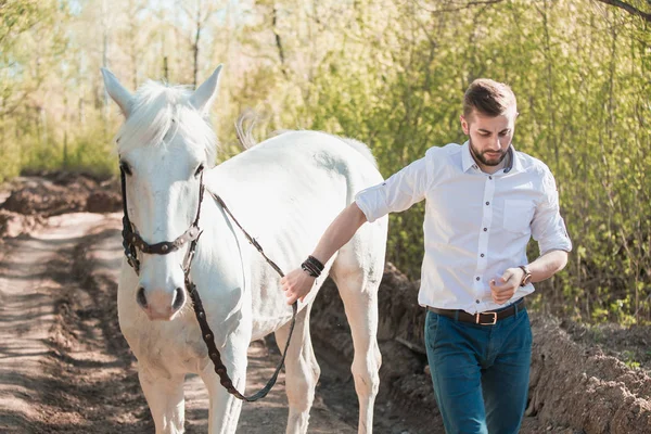 Young man with horse. Autumn outdoors scene