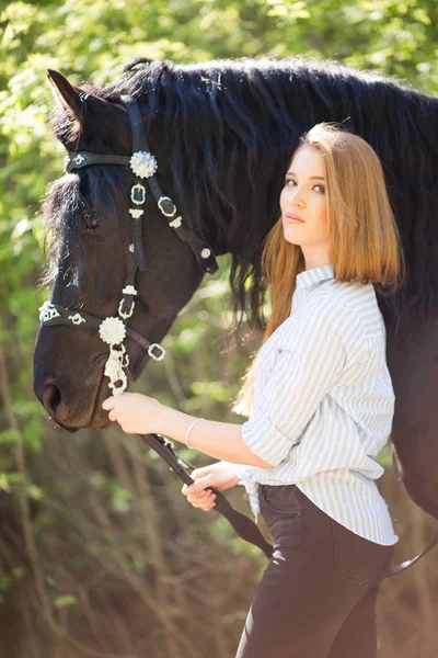 Krásná brunetka s dlouhými vlasy pózuje s červeným koněm v lese — Stock fotografie