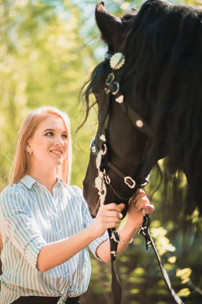Hermosa chica morena con el pelo largo posando con un caballo rojo en el bosque — Foto de Stock