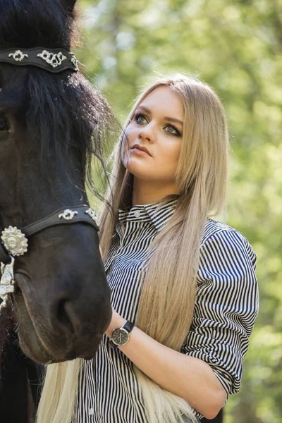 Schöne brünette Mädchen mit langen Haaren posiert mit einem roten Pferd im Wald — Stockfoto