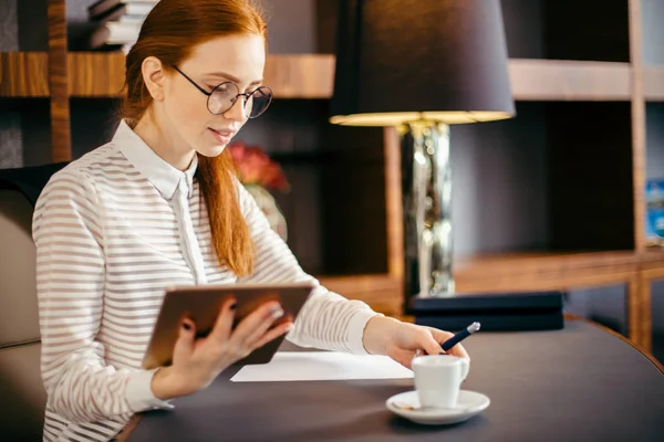 Rothaarige lächelnde junge Managerin nutzt modernes digitales Tablet im Büro — Stockfoto