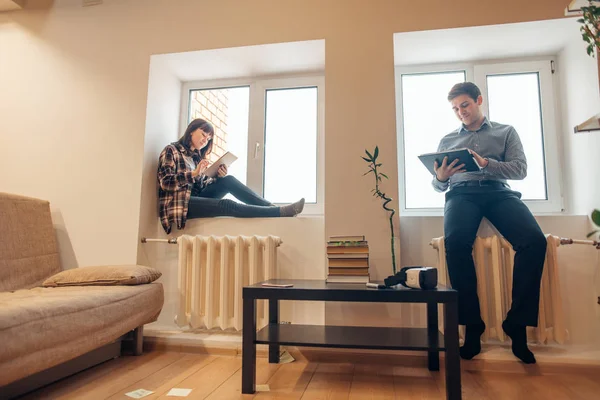 Man en vrouw rug aan rug zitten en doen hun werk — Stockfoto