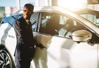 Afro-Amerikan sürücü onun yeni arabanın kapısını açarak