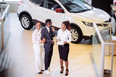 Araba özellikleri hakkında müşteriler için söylüyorum galerisinde duran araba satıcısı