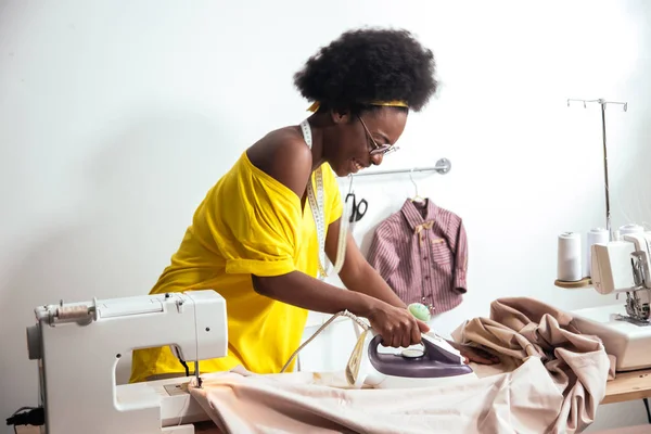 Afrikaanse vrouw naaister strijkdoek — Stockfoto