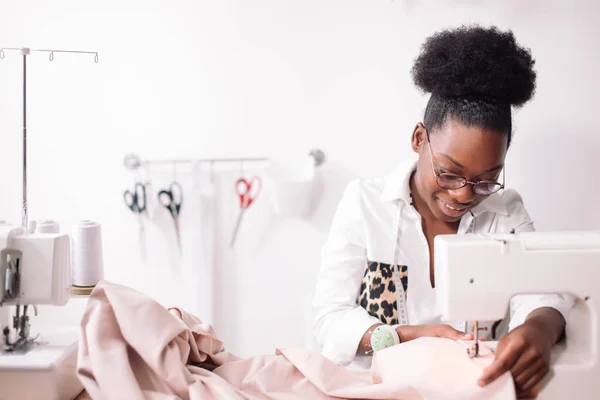 Two african dressmaker woman sews clothes on sewing machine and work with  scissors at tailor office. Black seamstress girls. 10417448 Stock Photo at  Vecteezy