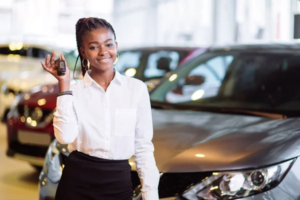 Donna africana con la sua nuova auto mostrando la chiave — Foto Stock