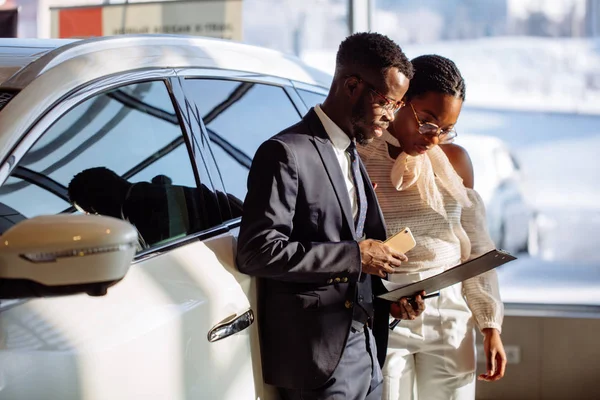 Autohändler zeigt schwarzer Frau Fahrzeug — Stockfoto