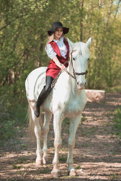 Brunette femme équitation sombre cheval à été vert forêt . — Photo