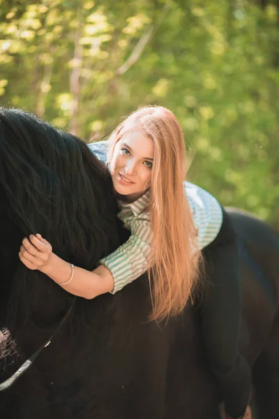 Young rider girl with long hair lying on horse neck — Stock Photo, Image