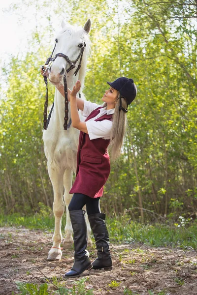 Bela menina morena com cabelos longos posando com um cavalo vermelho na floresta — Fotografia de Stock