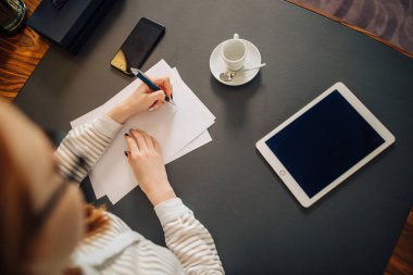 kadın oda ofis içinde dijital tablet bilgisayar ile kağıt üzerinde yazma