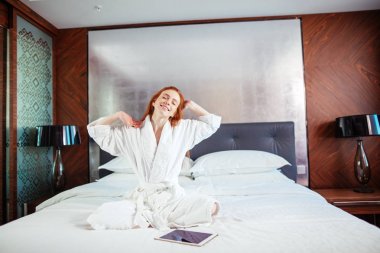 Uyanma sonra yatakta uzanan kızıl saçlı kadın