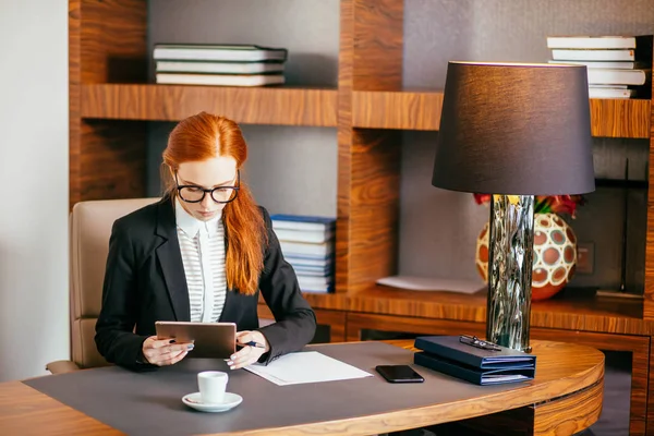 Donna d'affari che indossa gli occhiali utilizzando tablet digitale in ufficio — Foto Stock