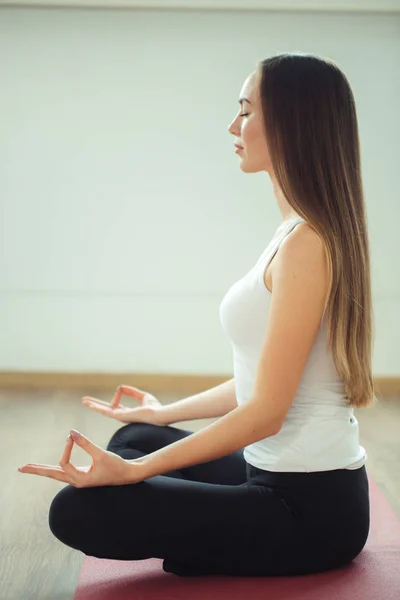 Mujer joven medita mientras practica yoga — Foto de Stock