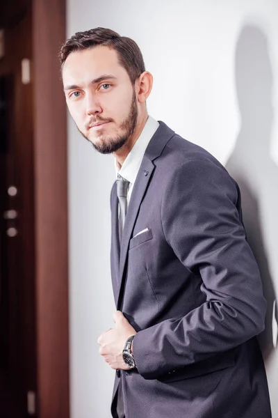 Homem de negócios feliz com braços cruzados de pé no escritório — Fotografia de Stock