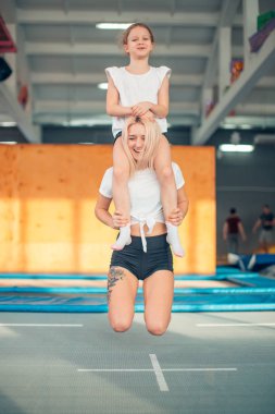 Anne ve kızı parkında oynarken. Anne boynunda oturan kız