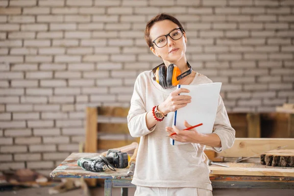 Trabajadora profesional con pluma y tableta en el taller — Foto de Stock