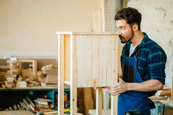 Timmerman testen houten plank gelijkmatigheid op workshop — Stockfoto