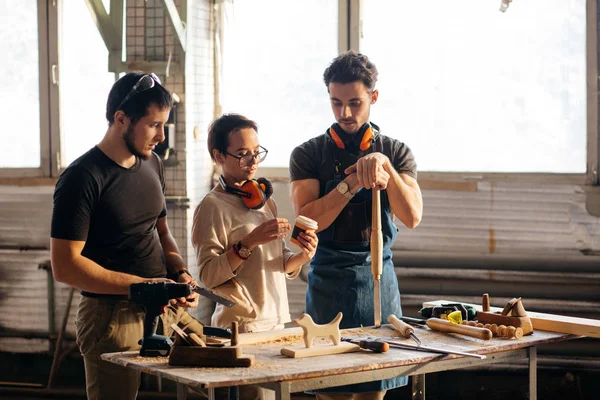 Carpintero entrenamiento hembra aprendiz a utilizar plano — Foto de Stock