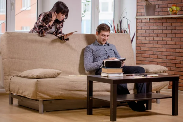 Studenten leren voor de examens samen met ebook in interieur — Stockfoto