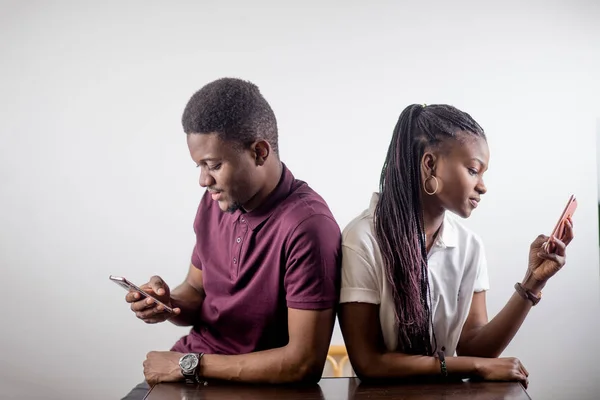 Africano casal segurando telefones celulares em uma mão — Fotografia de Stock