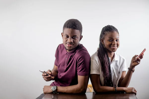 Afrikanisches Paar hält Mobiltelefone in der Hand — Stockfoto