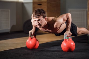 Spor salonu adam push-up gücü pushup egzersiz ile Kettlebell salonunda