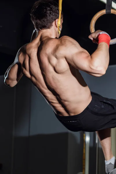 Árvore atraente jovens adultos masculinos e femininos fazendo pull ups no bar no ginásio — Fotografia de Stock