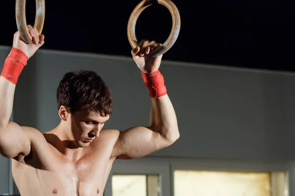 Árbol atractivo jóvenes hombres y mujeres adultos haciendo pull-ups en el bar en el gimnasio — Foto de Stock