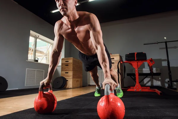 Güçlü delikanlı şınav mı kettlebells üzerinde