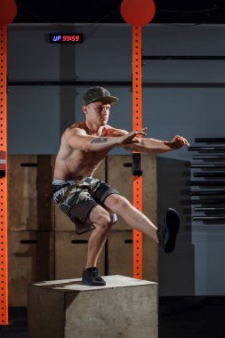 Acımasız dövmeli jimnastik antrenörü egzersiz bir bacak squat taşır gösterir