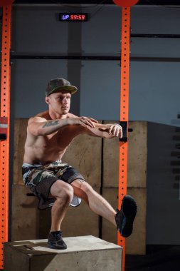 Acımasız dövmeli jimnastik antrenörü egzersiz bir bacak squat taşır gösterir